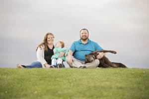 Family Picture on a hill with pet dog.