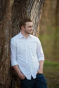 Senior photo with white dress shirt against tree.