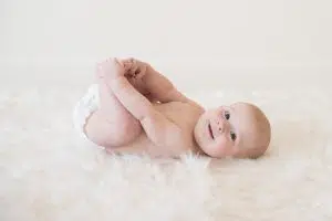 Smiling baby photo grabbing toes