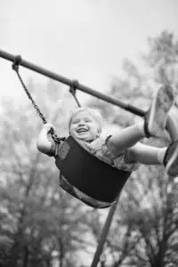 Fun kid picture of boy laughing on swing.