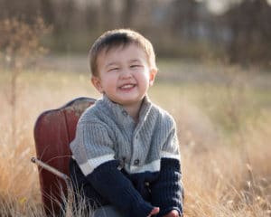 Kid picture of boy smiling in the prairie.