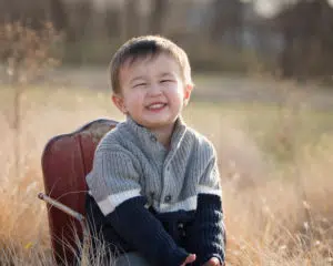 Kid picture of boy smiling in the prairie.