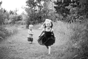 Professional black and white photo of kids running on a path