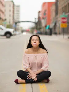 Photo of girl blowing bubbles in the road in downtown Rockford, IL.